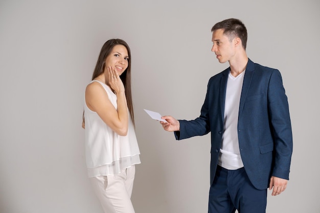 Business partner gives certificate to happy woman on gray background Caucasian