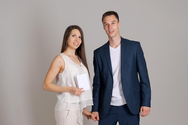 Business partner gives certificate to happy woman on gray background Caucasian