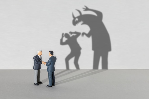 business partner monster businessmen shake hands but the shadow indicates that one monster