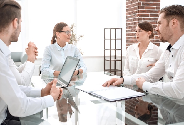 Business partners are discussing a new contract sitting at the Deskmeetings and partnerships