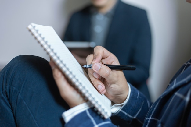 Business partners concept a young businessman holding a pen pointing at profit summary of the recent month showing in document forms.