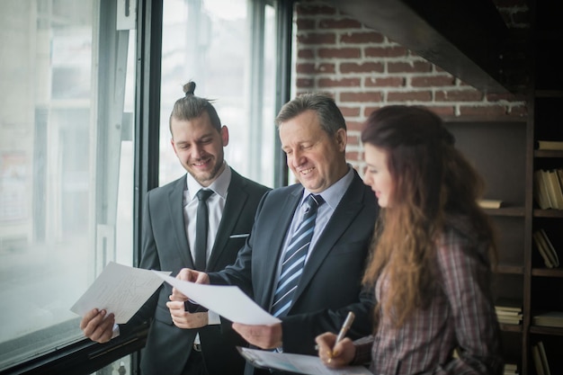 Photo business partners discussing business documents standing in the