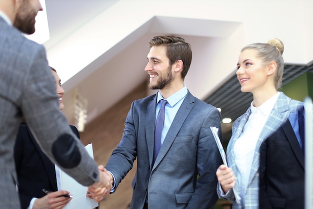 Stretta di mano dei partner commerciali su oggetti aziendali sul posto di lavoro.