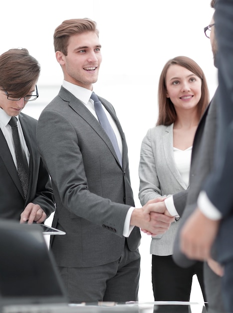 Business partners handshaking with their colleagues