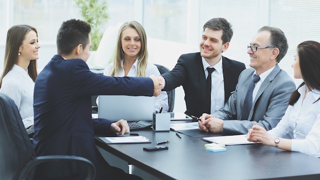 Photo business partners shaking hands after a successful transaction