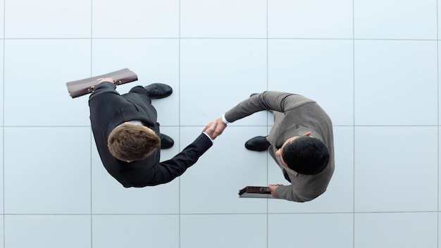 Photo business partners shaking hands as a symbol of unity view from the top