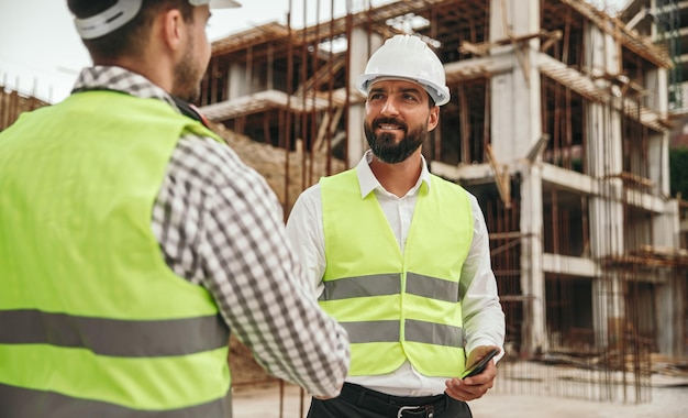 Business partners shaking hands on construction site