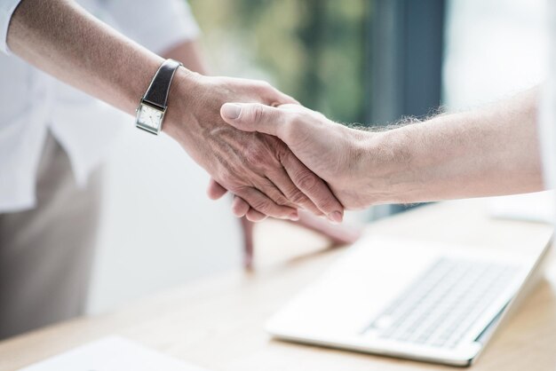 Business partners shaking hands at office