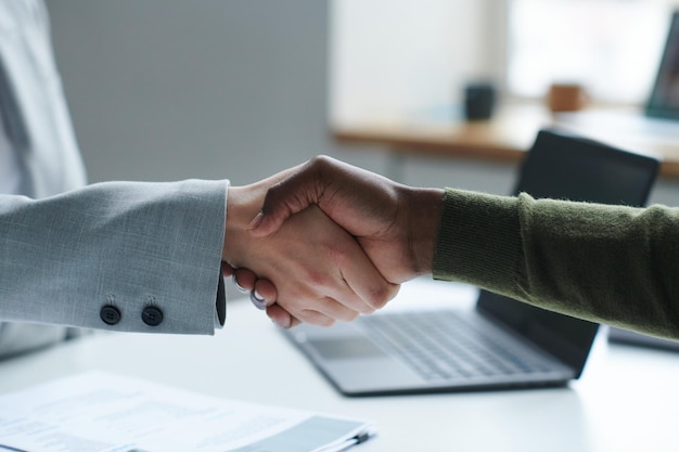 Business partners shaking hands at table