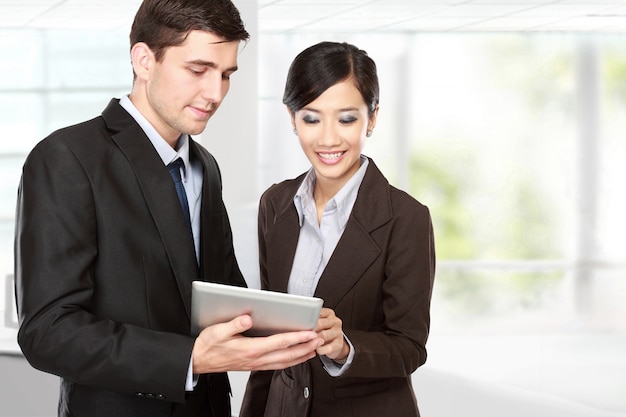 Business partners using touchpad at meeting