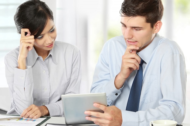 Business partners using touchpad at meeting