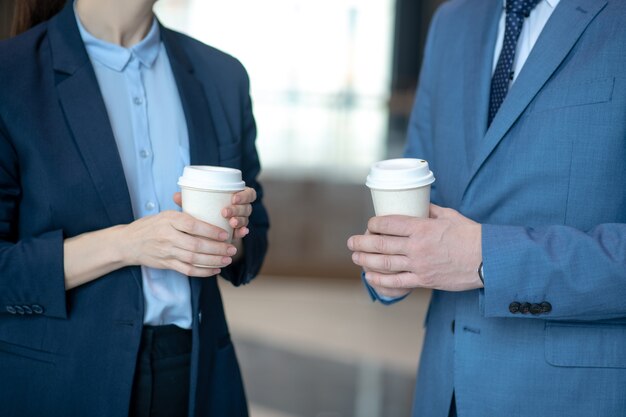 Photo business partners with coffees in the office