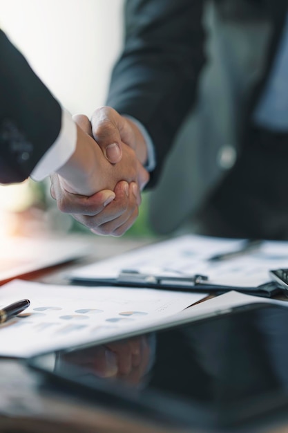 Business partnership meeting concept businessmans handshake\
successful businessmen handshaking after good deal vertical blurred\
background