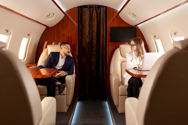 Photo business people are flying in private luxury plane asian businessman in suit and woman manager