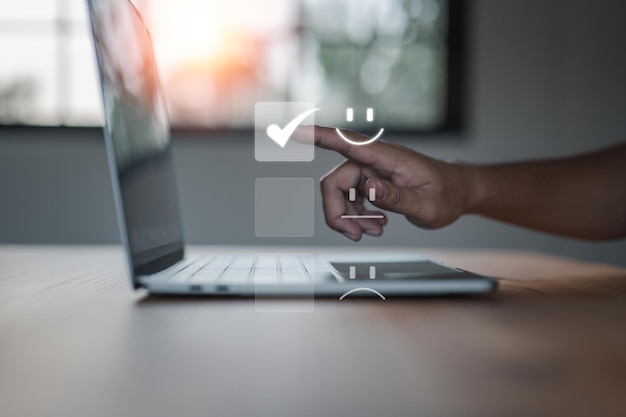 ビジネスマンは、笑顔のスマイリーフェイスアイコンの仮想画面に触れて、カスタマーサービスのアイデアに非常に感銘を受けた評価で幸せを表現しています