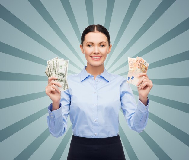 business, people, banking and finances concept - young businesswoman with dollar and euro cash money over blue burst rays background