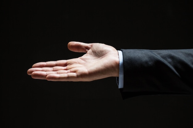 business, people, bankruptcy and advertisement concept - close up of businessman with empty hand over black