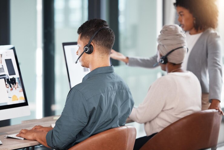 Photo business people call center and coach with team in customer service support or training staff at office group of employee consultants or agents with manager for telemarketing or virtual assistance