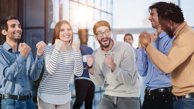 Foto gli uomini d'affari festeggiano e stringono i pugni in aria come una squadra vincente.