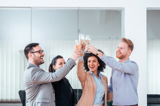 Foto uomini d'affari che celebrano il successo con un bicchiere di champagne.