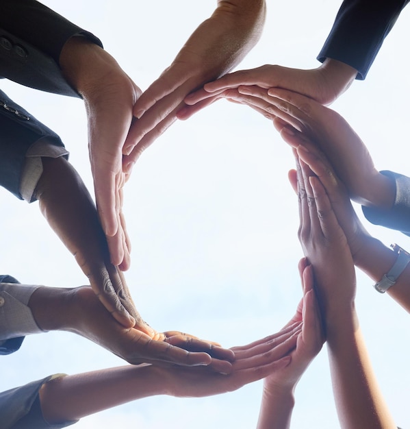 Business people circle and hands with teamwork sky and planning with cooperation synergy and solidarity Closeup group and employees with support collaboration and community with trust and unity