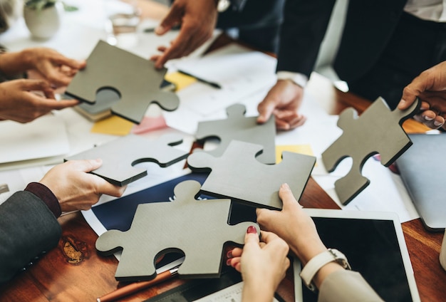 Business people connecting puzzle pieces together