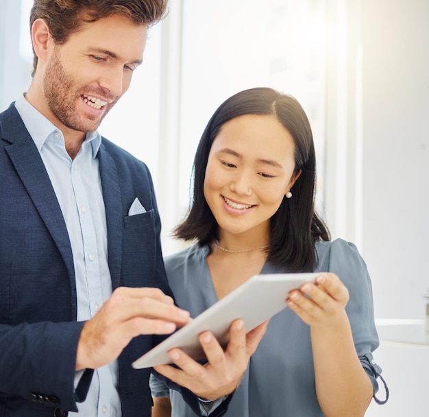 Business people conversation and tablet research together in an office Asian woman employee reading a report review with a businessman while talking and planning a company strategy with data