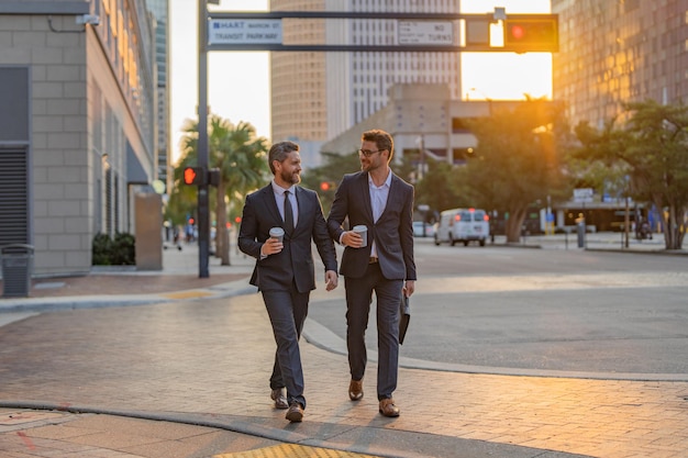 Business people discuss a project two young businessmen outdoors city looking cityscape businessmen