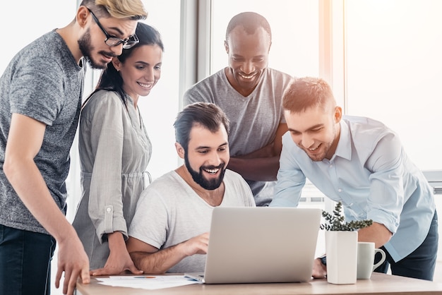 Business people discussing over laptop at table in office