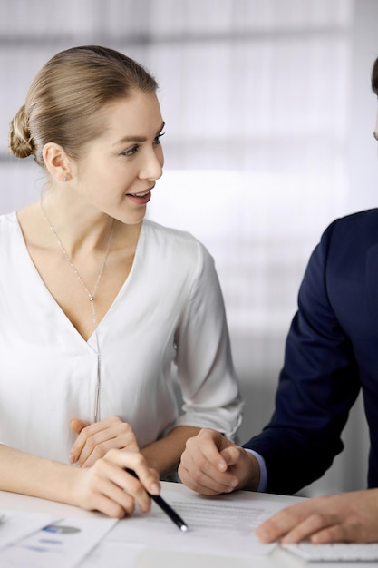 Business people discussing something while sitting in office Focus at businesswoman while talking to her male colleague Teamwork and meeting concept