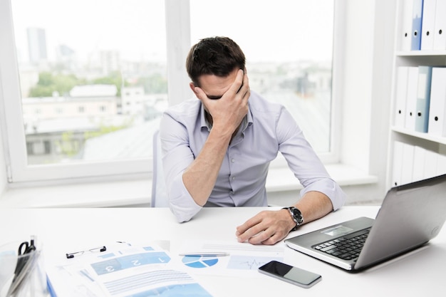 Photo business, people, fail, paperwork and technology concept - businessman with laptop computer and papers working in office