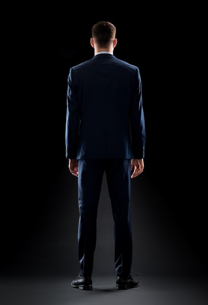 business, people, formalwear, fashion and office style concept - businessman in suit over black background