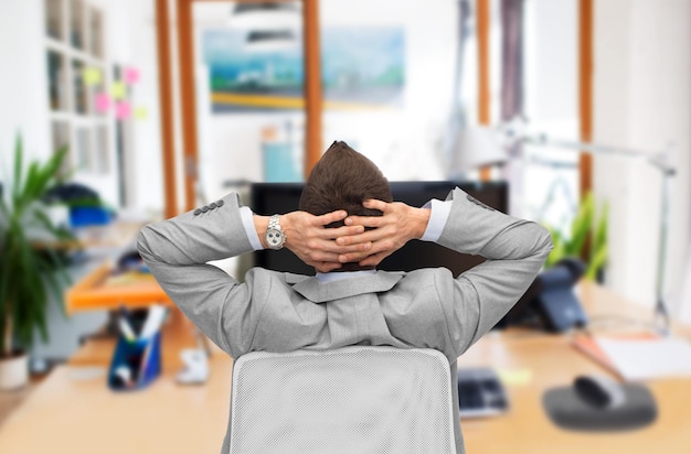 Photo business, people, furniture, rear view and office concept - businessman sitting in chair from back over office room background