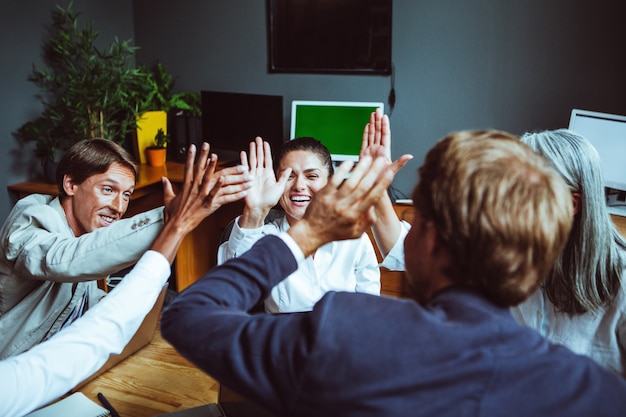 Business people giving each other high five and clapping. Business team celebrating success.