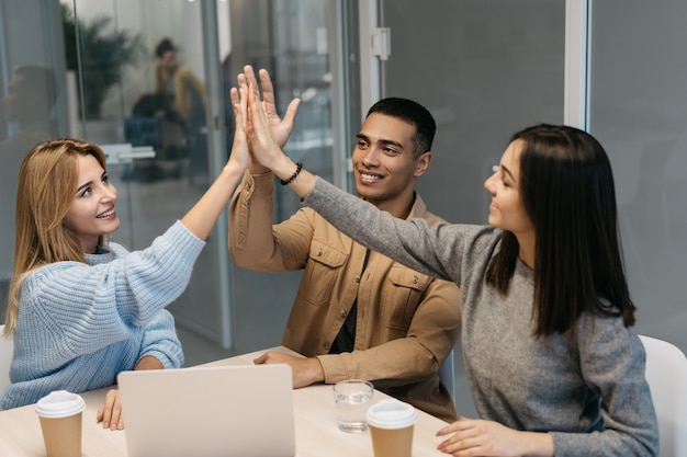 Business people giving high five, meeting in office