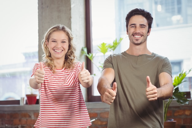 Business people giving thumbs up 