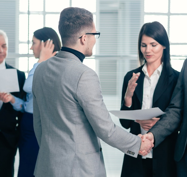 Business people greet each other with a handshake in the office lobby. business concept