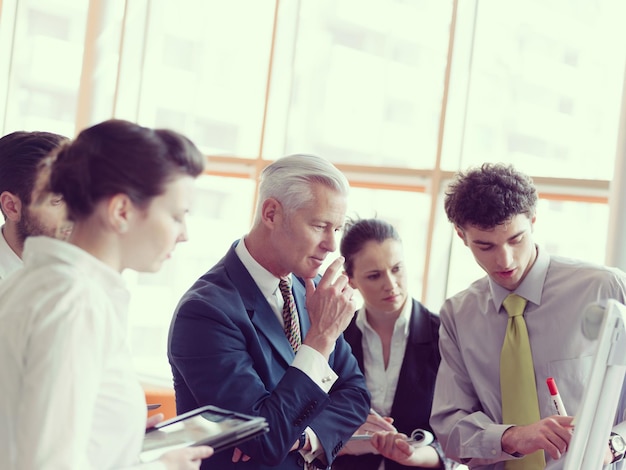 Gruppo di uomini d'affari di brainstorming su riunioni e uomini d'affari che presentano idee e progetti sulla lavagna al senior ceo manager