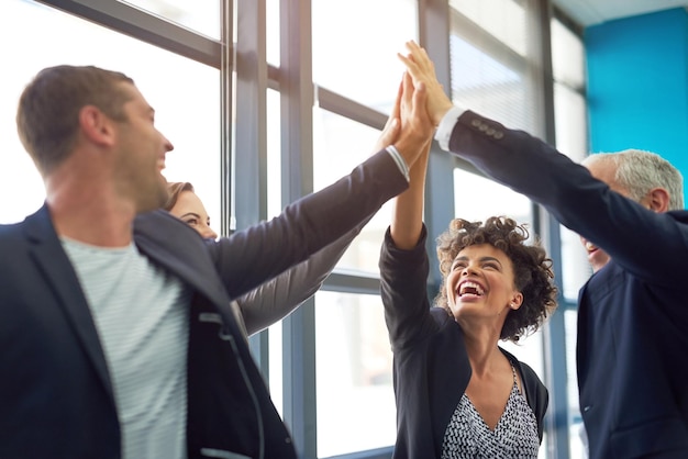 Деловые люди объединяются в группу «дай пять» и празднуют в офисе с командной улыбкой и поддержкой целей компании. Мужчины, женщины и руки в воздухе для достижения командной работы и мотивации в страховом агентстве.
