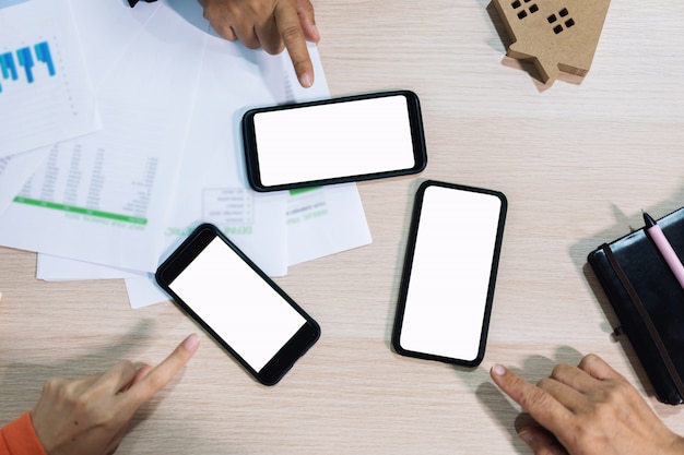 Business people hands using smart phone white screen on top view