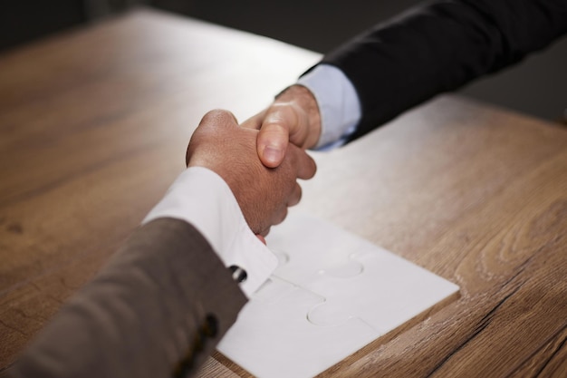 Foto stretta di mano della gente di affari sopra il concetto di partenariato e di accordo degli uomini d'affari della tavola di legno