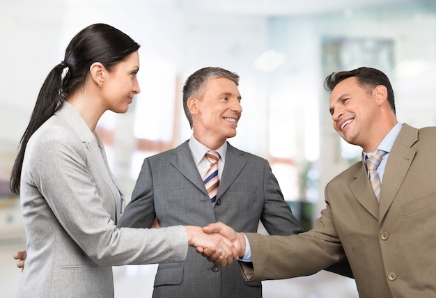 Business people handshaking at meeting on background