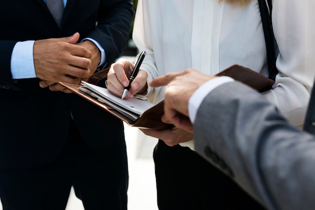 Business people having a business talk and business woman noting down information on a notebook