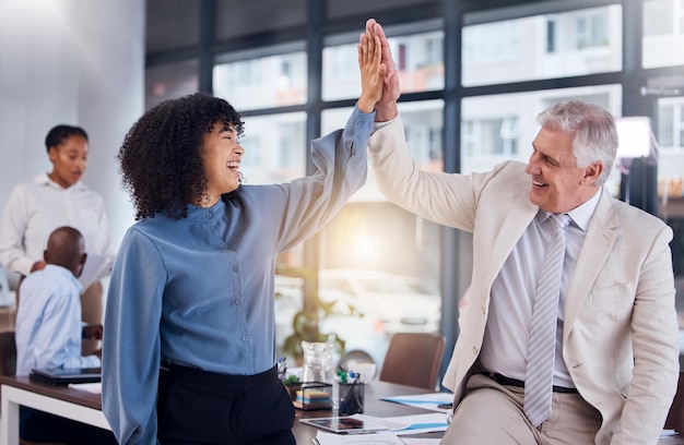 Business people high five and celebration for success collaboration or teamwork at the office Happy black woman touching hand of senior man CEO celebrating team strategy management or leadership