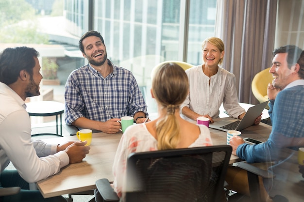 Business people holding coffee mug during a meeting