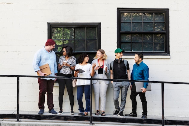 Business people holding digital devices while waiting in line