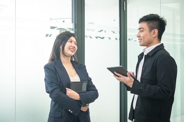 Business people holding digital tablet and talking to each other