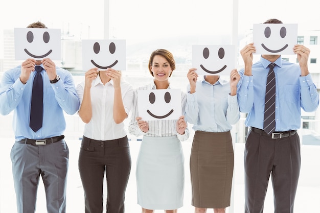 Photo business people holding happy smileys