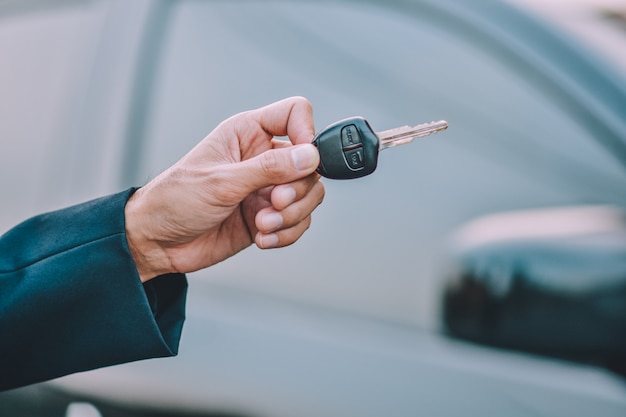 Business people holding key at car