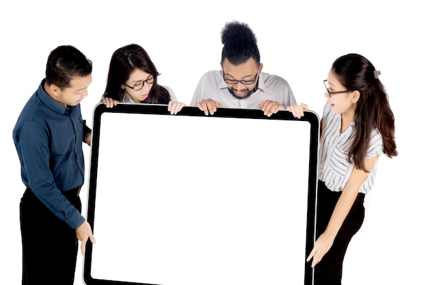 Business people holding whiteboard on studio